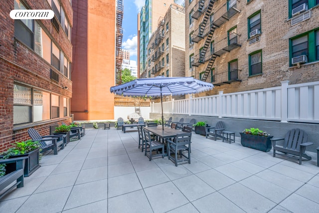 view of patio featuring fence, outdoor dining space, and cooling unit