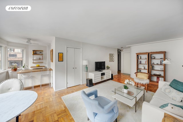 living area featuring visible vents, baseboards, and ceiling fan