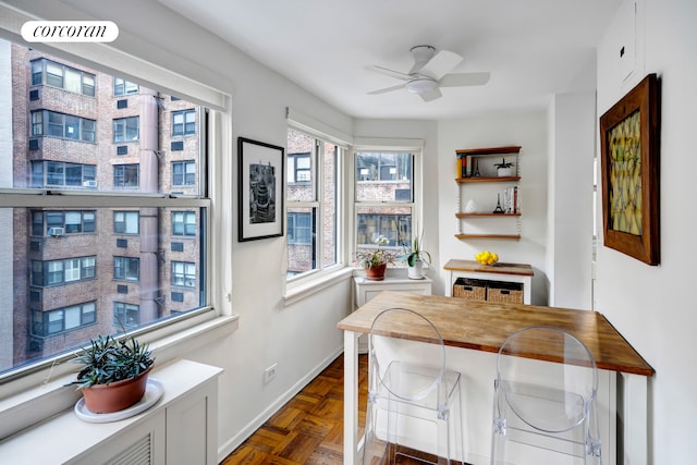 interior space with a ceiling fan and baseboards