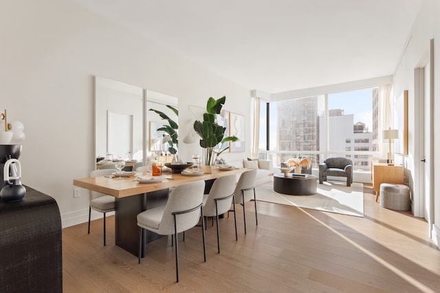 77 Greenwich St Unit 33C, New York City, NY 10006 - dining room with floor to ceiling windows, a view of city, baseboards, and wood finished floors