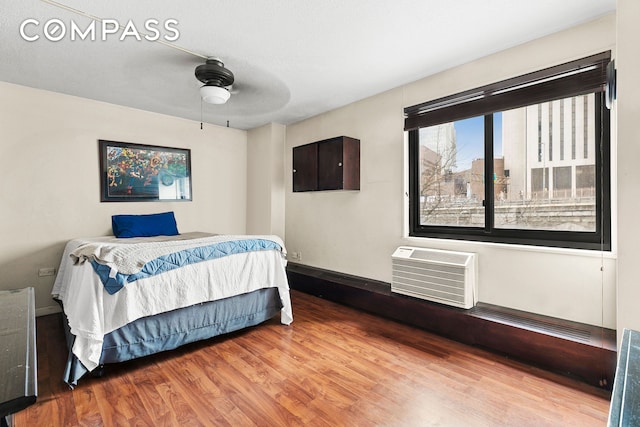 333 Pearl St Unit 6K, New York City, NY 10038 - bedroom featuring wood finished floors, a wall mounted air conditioner, and a ceiling fan