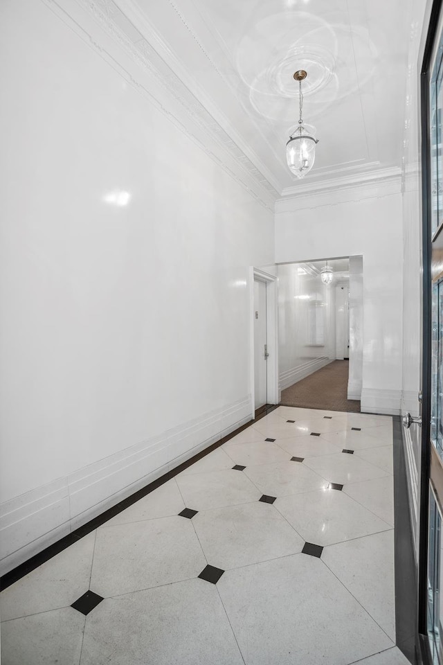 17 E 80th St Unit 6/3R, New York City, NY 10075 - corridor featuring crown molding, tile patterned flooring, a towering ceiling, and a chandelier