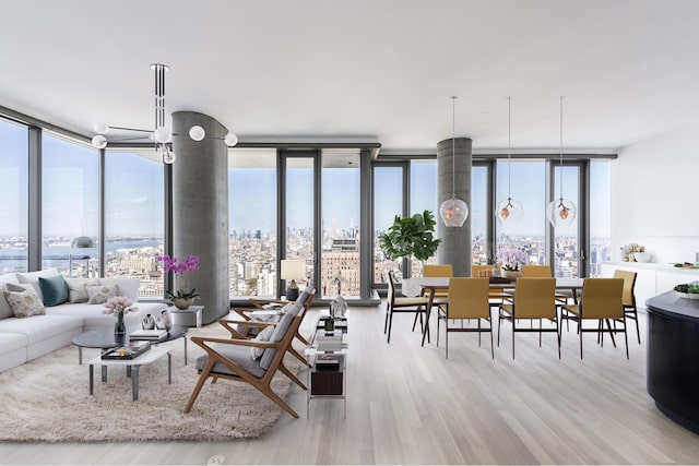 living area featuring floor to ceiling windows, plenty of natural light, and wood finished floors