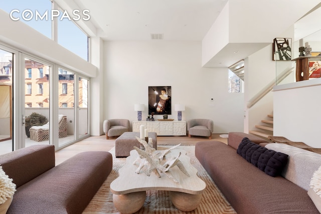 276 Berry St, New York City, NY 11249 - living area featuring visible vents, stairway, and light wood-style floors
