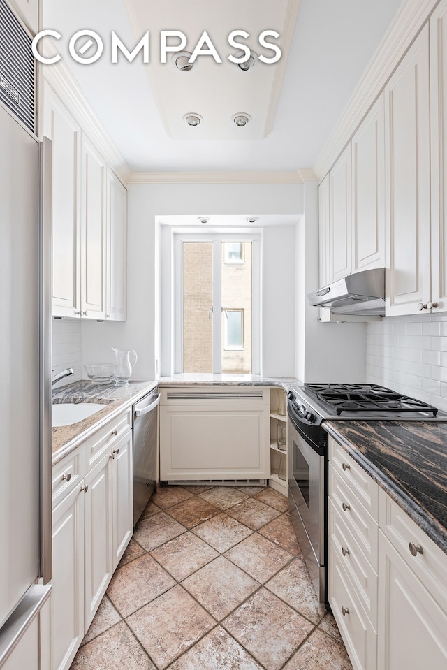135 E 71st St Unit 9D, New York City, NY 10021 - kitchen with appliances with stainless steel finishes, under cabinet range hood, a sink, crown molding, and white cabinets