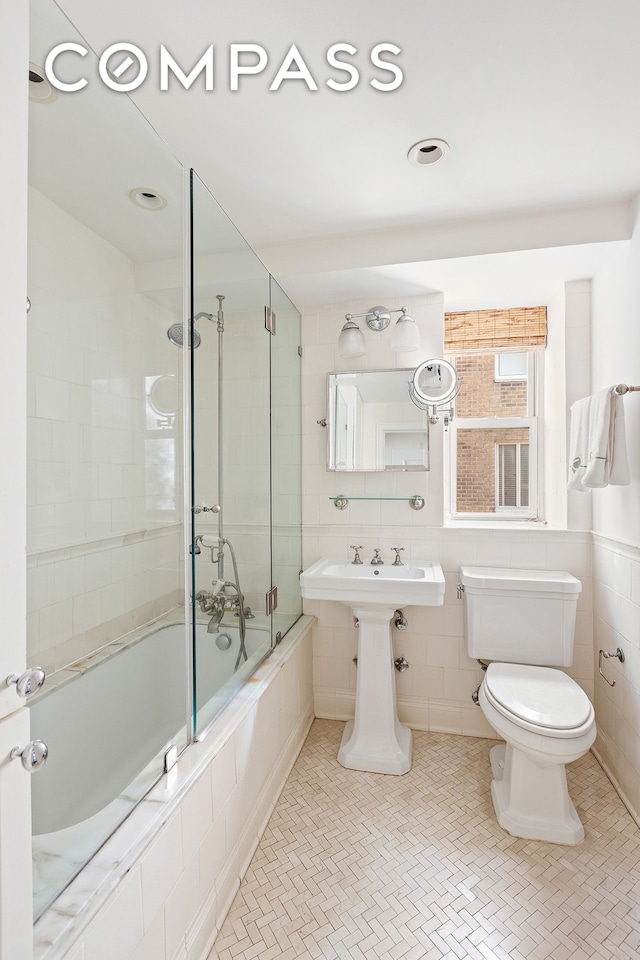 135 E 71st St Unit 9D, New York City, NY 10021 - bathroom featuring toilet, tiled shower / bath combo, tile walls, and tile patterned floors