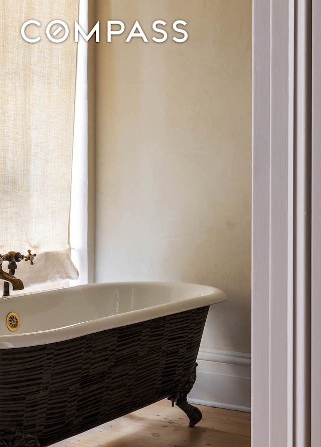 125 W 15th St, New York City, NY 10011 - bathroom with a freestanding tub and wood finished floors