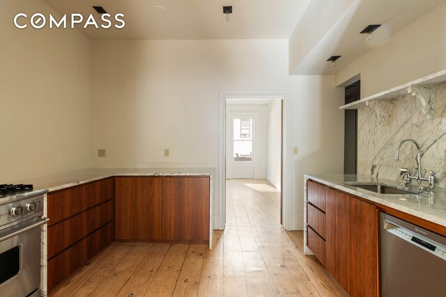 125 W 15th St, New York City, NY 10011 - kitchen featuring stainless steel appliances, modern cabinets, tasteful backsplash, and brown cabinets