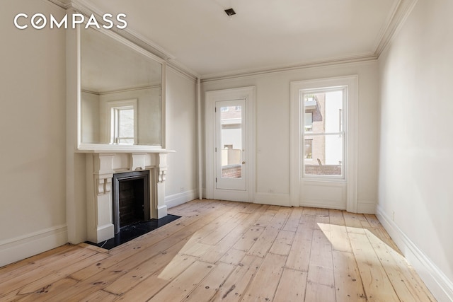 125 W 15th St, New York City, NY 10011 - unfurnished living room with wood-type flooring, plenty of natural light, a fireplace, and ornamental molding