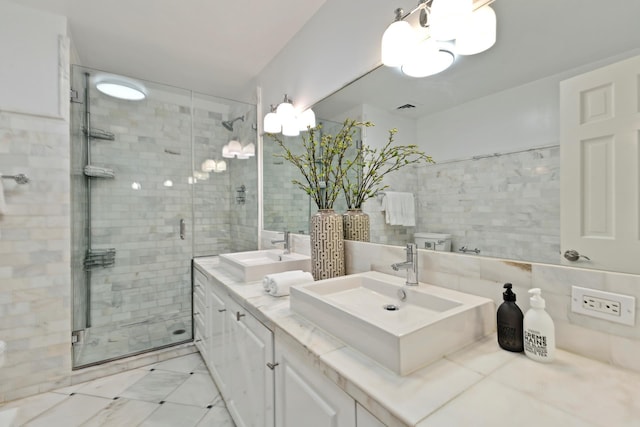 bathroom featuring double vanity, a sink, a shower stall, and tile walls