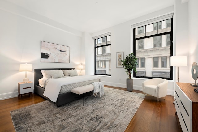 bedroom featuring baseboards and dark wood-type flooring