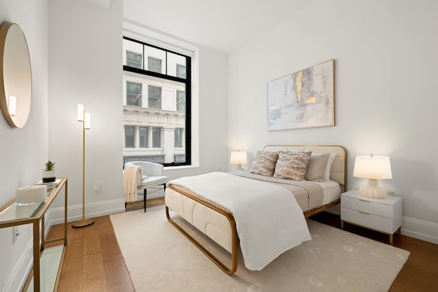 bedroom with baseboards and wood finished floors