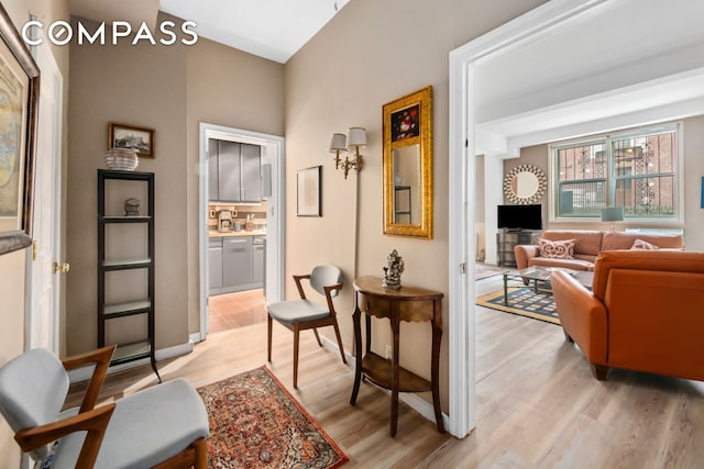 living area featuring light wood-style floors and baseboards