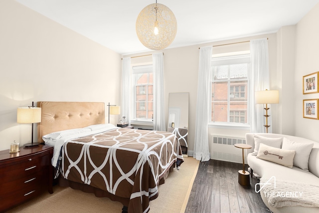 bedroom with radiator and wood finished floors