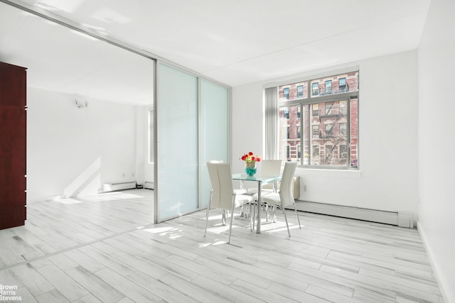 dining space featuring a baseboard radiator and wood finished floors