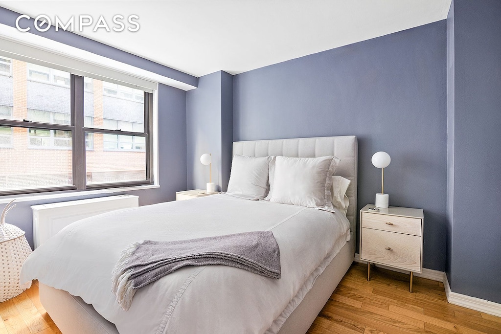 bedroom with baseboards and wood finished floors