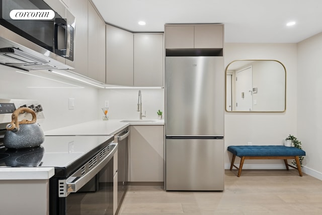 608 Ocean Ave Unit 403, New York City, NY 11226 - kitchen featuring stainless steel appliances, a sink, modern cabinets, light countertops, and light wood-style flooring