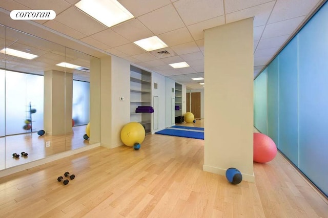 555 W 59th St Unit 18G, New York City, NY 10019 - exercise room featuring wood finished floors, baseboards, and a paneled ceiling