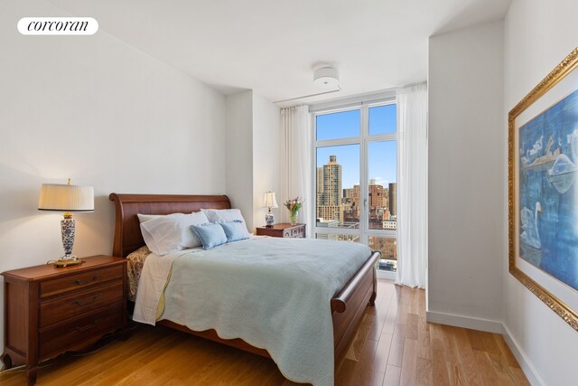 555 W 59th St Unit 18G, New York City, NY 10019 - bedroom with light wood-style flooring and baseboards