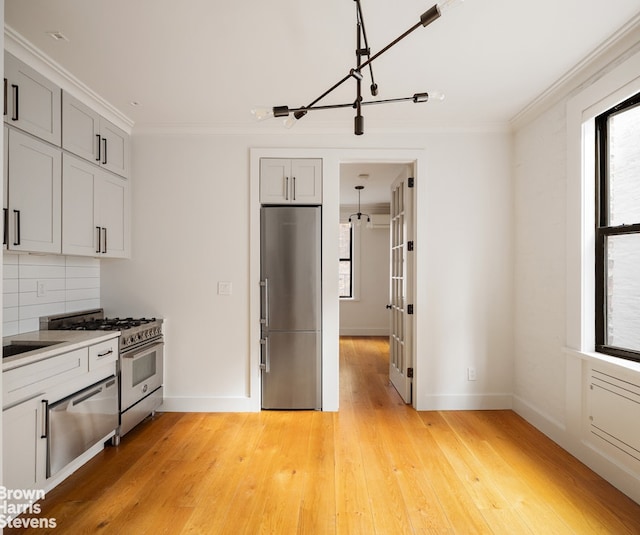 139 E 30th St Unit 5C, New York City, NY 10016 - kitchen with appliances with stainless steel finishes, a warming drawer, ornamental molding, light wood-style flooring, and backsplash