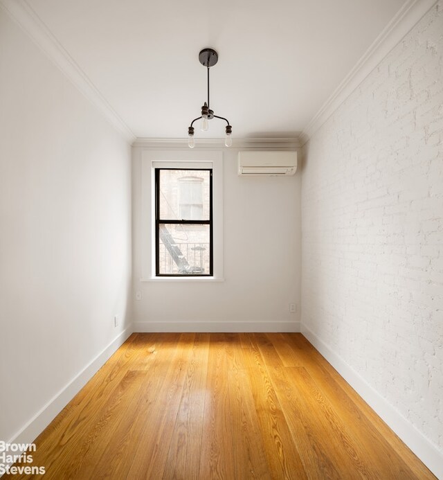 139 E 30th St Unit 5C, New York City, NY 10016 - unfurnished room featuring a wall unit AC, light wood-style flooring, ornamental molding, baseboards, and brick wall