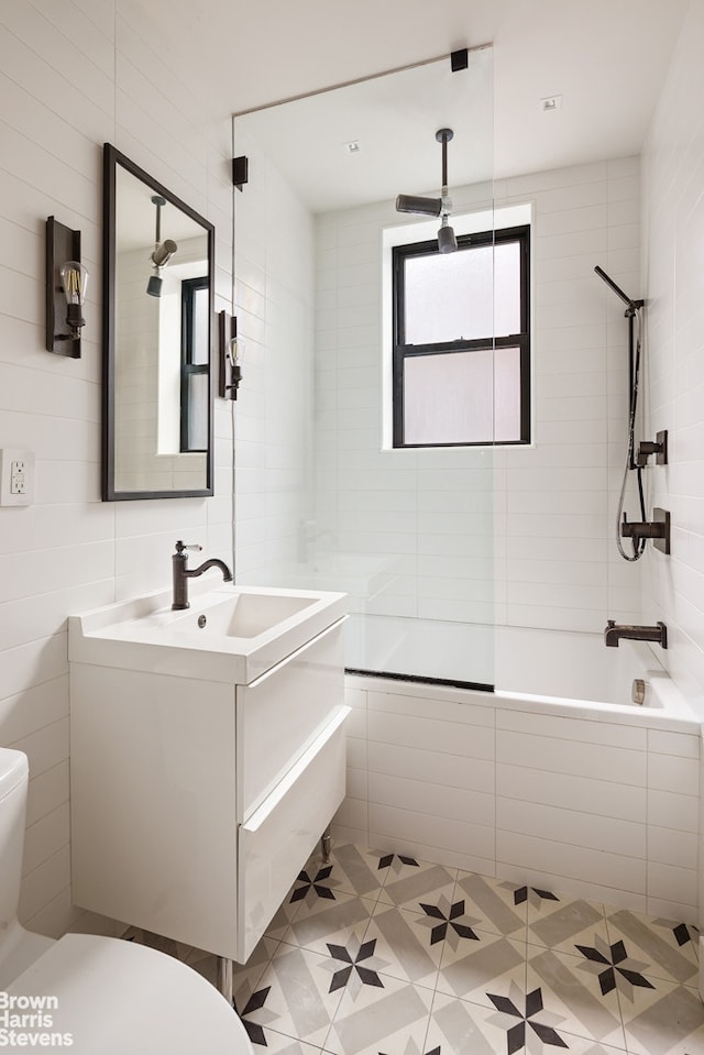 139 E 30th St Unit 5C, New York City, NY 10016 - full bathroom featuring toilet, tiled shower / bath, vanity, tile walls, and tile patterned flooring