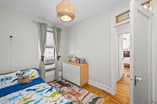 bedroom with wood finished floors and baseboards