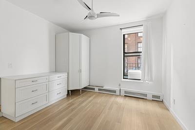 14 Prince St Unit 2-F, New York City, NY 10012 - unfurnished bedroom with light wood finished floors and ceiling fan