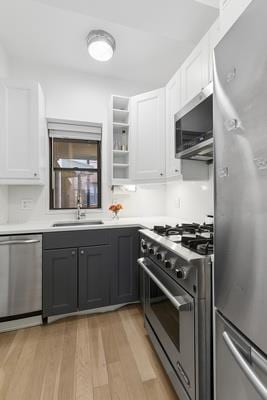 14 Prince St Unit 2-F, New York City, NY 10012 - kitchen with appliances with stainless steel finishes, light wood-style flooring, white cabinetry, and light countertops