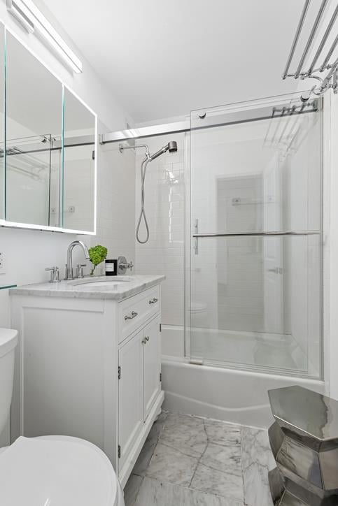 14 Prince St Unit 2-F, New York City, NY 10012 - full bath with toilet, vanity, marble look tiles, and enclosed tub / shower combo
