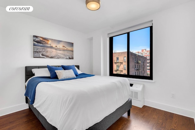 bedroom featuring visible vents, baseboards, and wood finished floors