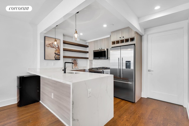 kitchen featuring a peninsula, open shelves, visible vents, a sink, and stainless steel appliances
