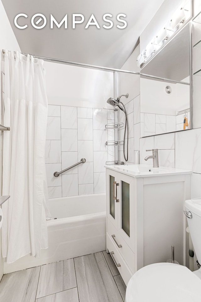 bathroom featuring toilet, shower / bath combo with shower curtain, and vanity