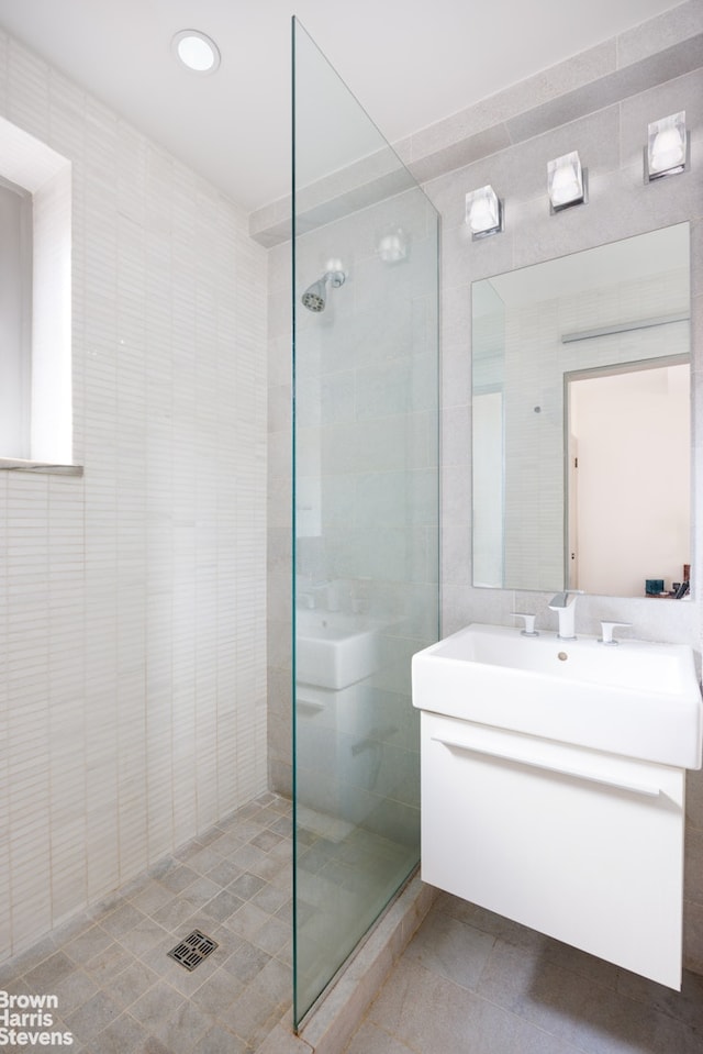 1 W 67th St Unit 309, New York City, NY 10023 - full bath with tile walls, a tile shower, vanity, tile patterned floors, and recessed lighting