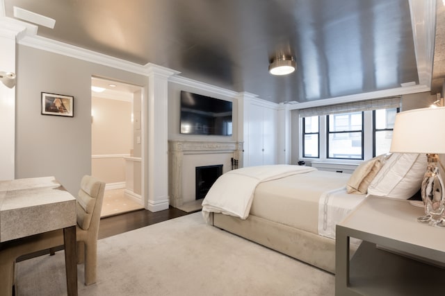 220 E 73rd St Unit 6Cde, New York City, NY 10021 - bedroom featuring crown molding, dark wood-style flooring, baseboards, and a fireplace