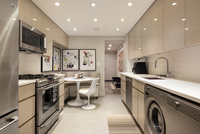 220 E 73rd St Unit 6Cde, New York City, NY 10021 - kitchen with a sink, washer / dryer, modern cabinets, and stainless steel appliances