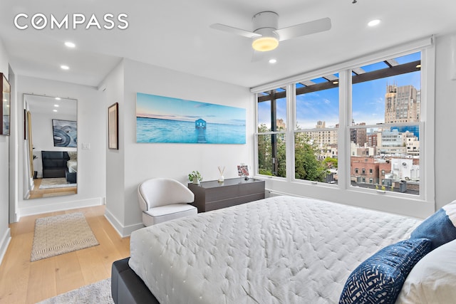 240 W 23rd St Phc, Phc, New York City, NY 10011 - bedroom featuring wood finished floors, a view of city, baseboards, recessed lighting, and ceiling fan