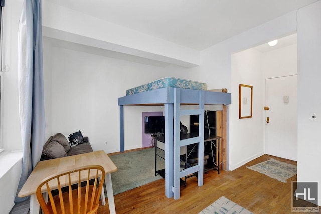bedroom featuring wood finished floors and baseboards