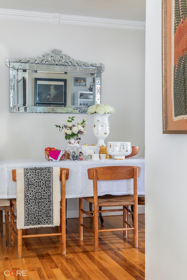 dining room with ornamental molding and wood finished floors
