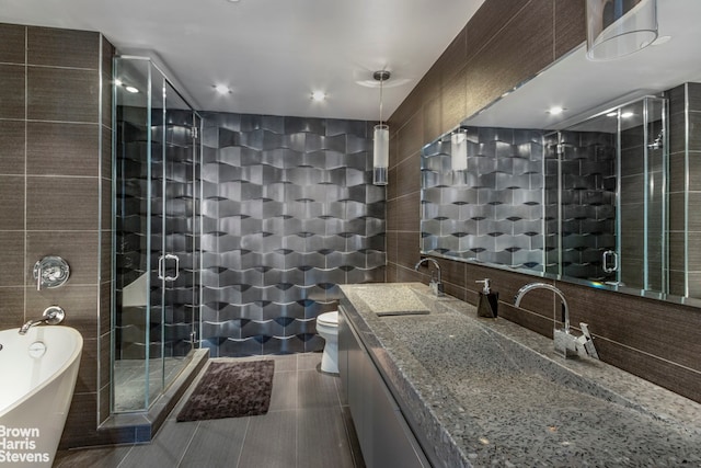 full bath with tile patterned flooring, a freestanding tub, tile walls, a shower stall, and backsplash