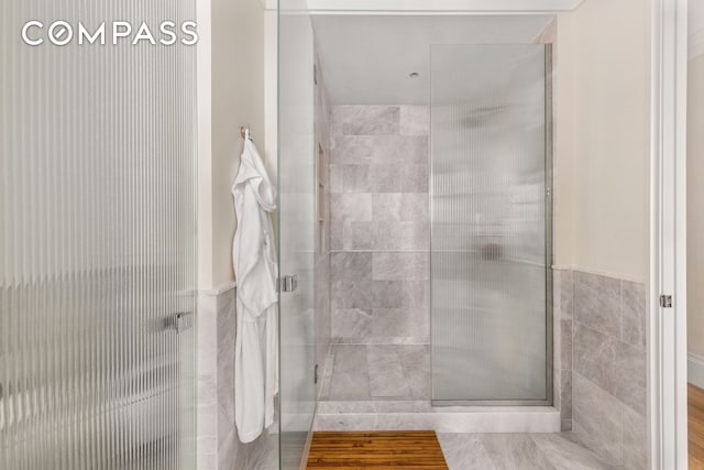 250 E 21st St Unit 10A, New York City, NY 10010 - bathroom with a stall shower, tile walls, and a wainscoted wall