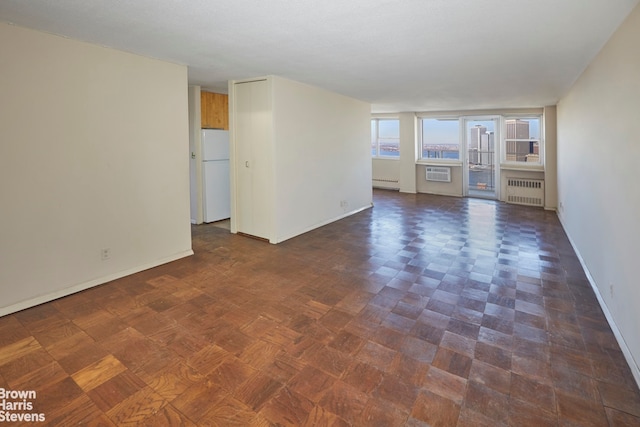 75 Henry St Unit 30K, New York City, NY 11201 - empty room featuring radiator heating unit, baseboard heating, baseboards, and a wall mounted AC