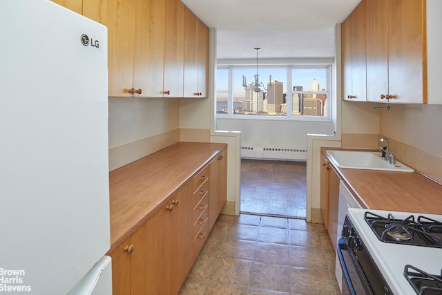 75 Henry St Unit 30K, New York City, NY 11201 - kitchen with freestanding refrigerator, range with gas cooktop, a sink, a baseboard radiator, and light countertops