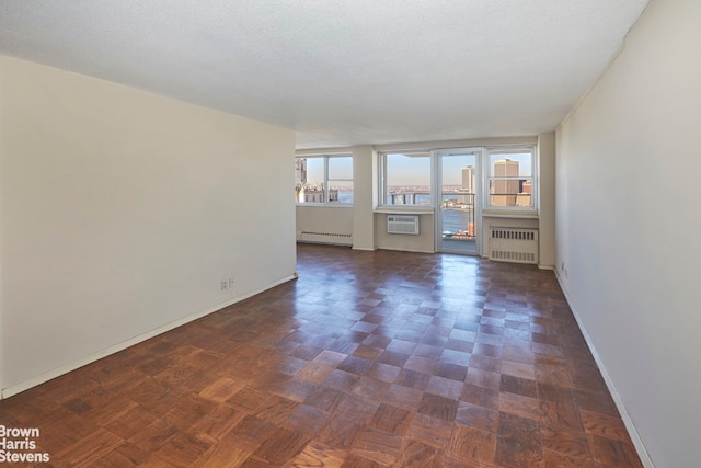 75 Henry St Unit 30K, New York City, NY 11201 - spare room featuring radiator heating unit, a baseboard radiator, baseboards, and a wall mounted air conditioner