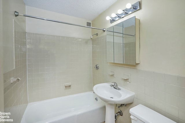 75 Henry St Unit 30K, New York City, NY 11201 - bathroom with toilet, shower / bath combination, a textured ceiling, and tile walls