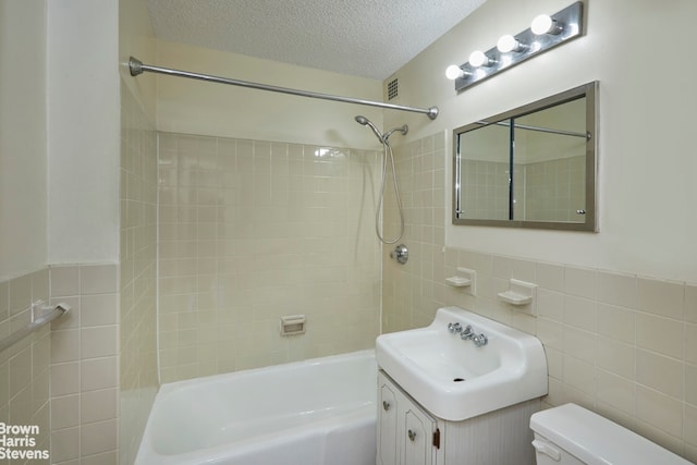 75 Henry St Unit 30K, New York City, NY 11201 - bathroom featuring tile walls, toilet, vanity, shower / bath combination, and a textured ceiling