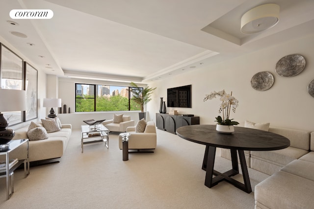 living room with a tray ceiling, carpet, and visible vents