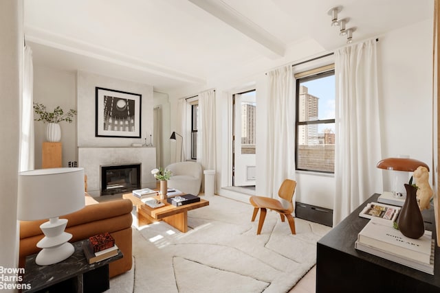 living room with beamed ceiling, light colored carpet, and a glass covered fireplace