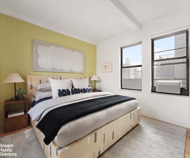 bedroom with cooling unit, wood finished floors, beamed ceiling, and baseboards
