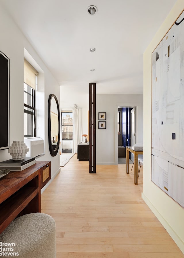 hall with baseboards, light wood-type flooring, and recessed lighting